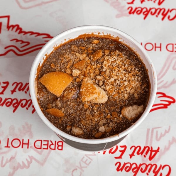 Top-down view of a Bred Hot Chicken banana pudding cup with crushed wafers.
